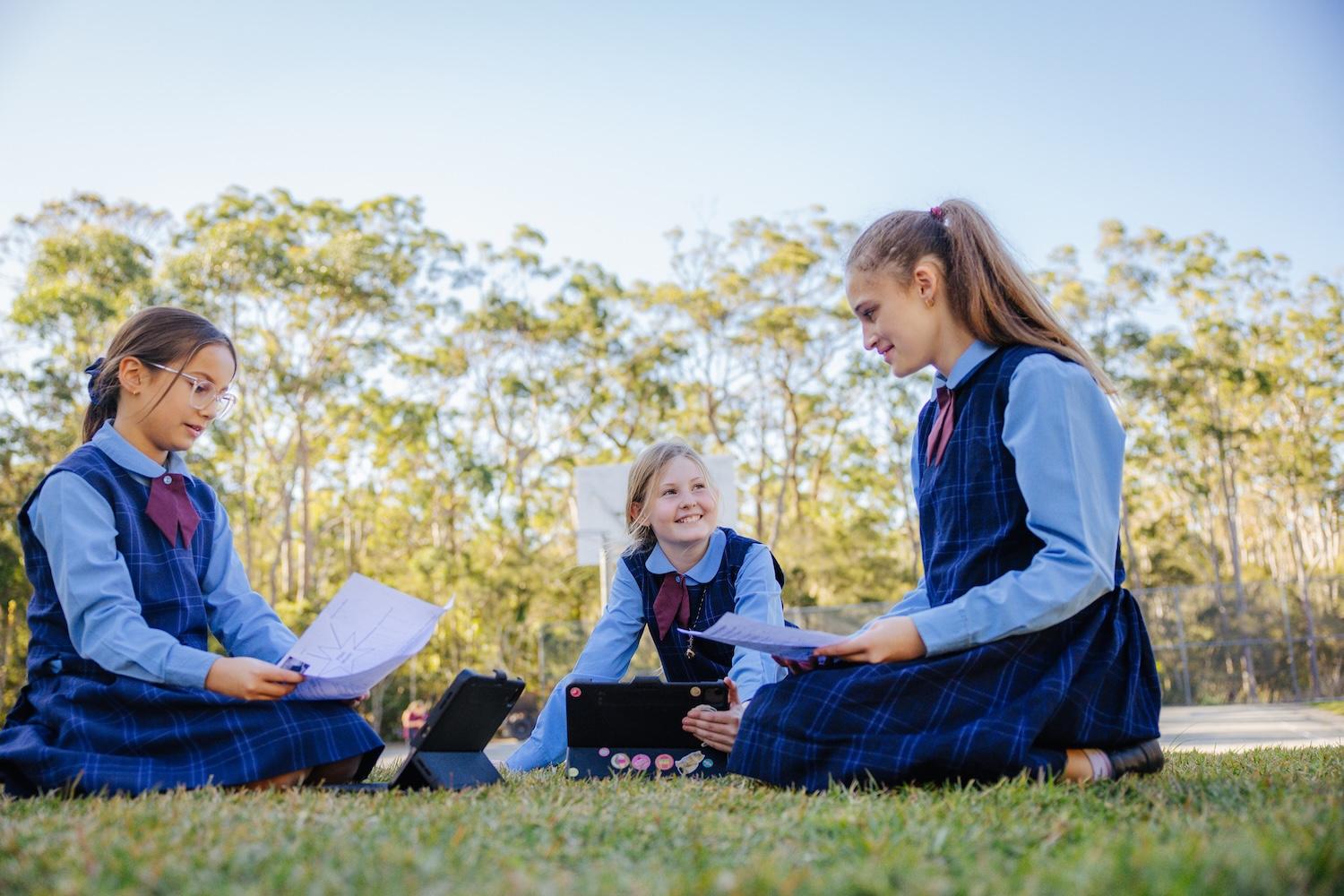 Three Medowie Christian School students studying and collaborating outdoors, showcasing the school’s engaging learning environment.