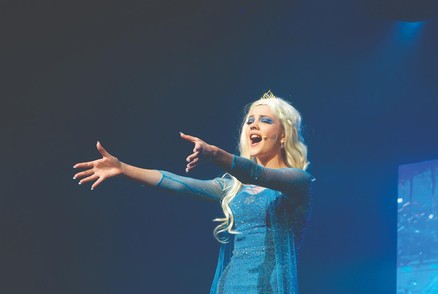 A student performing as Elsa in an all-school production of Frozen, as part of the school’s performing arts program.