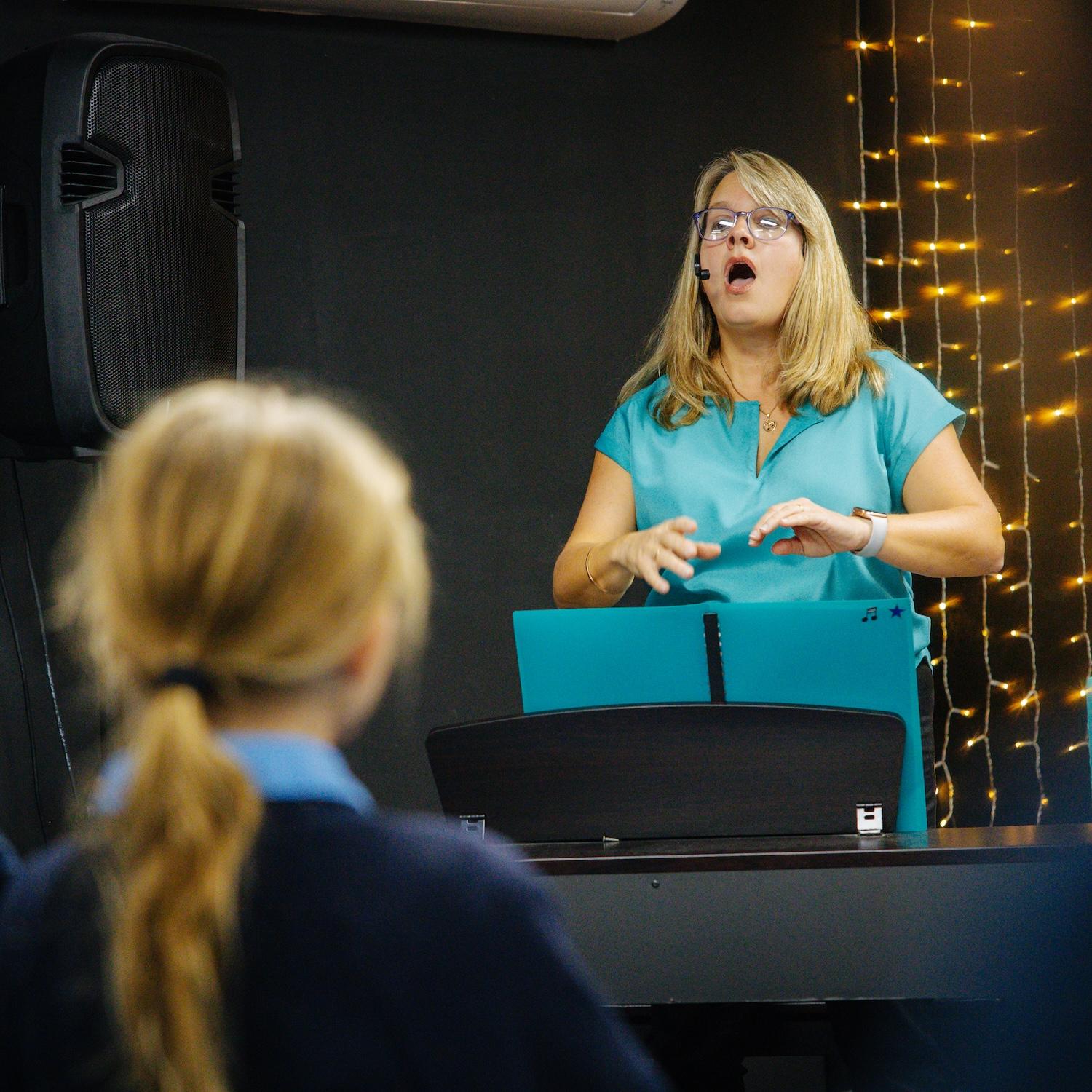 Music tutor conducting a lesson at Medowie Christian School, guiding students in vocal performance.