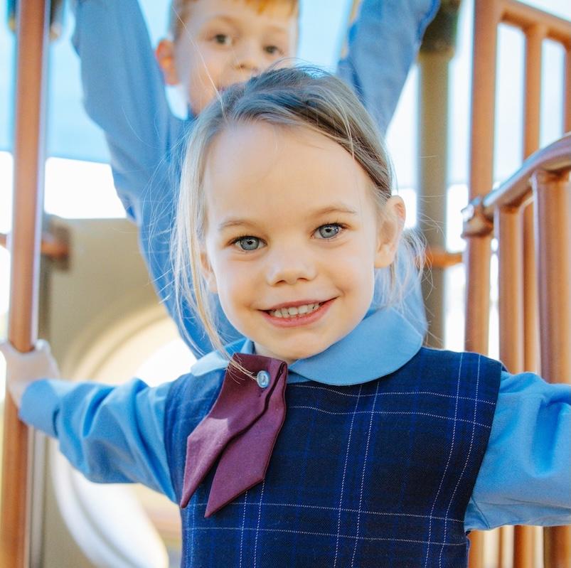 Close up of a smiling student on a playground, who is well known and nutured by the community at Medowie Christian College.