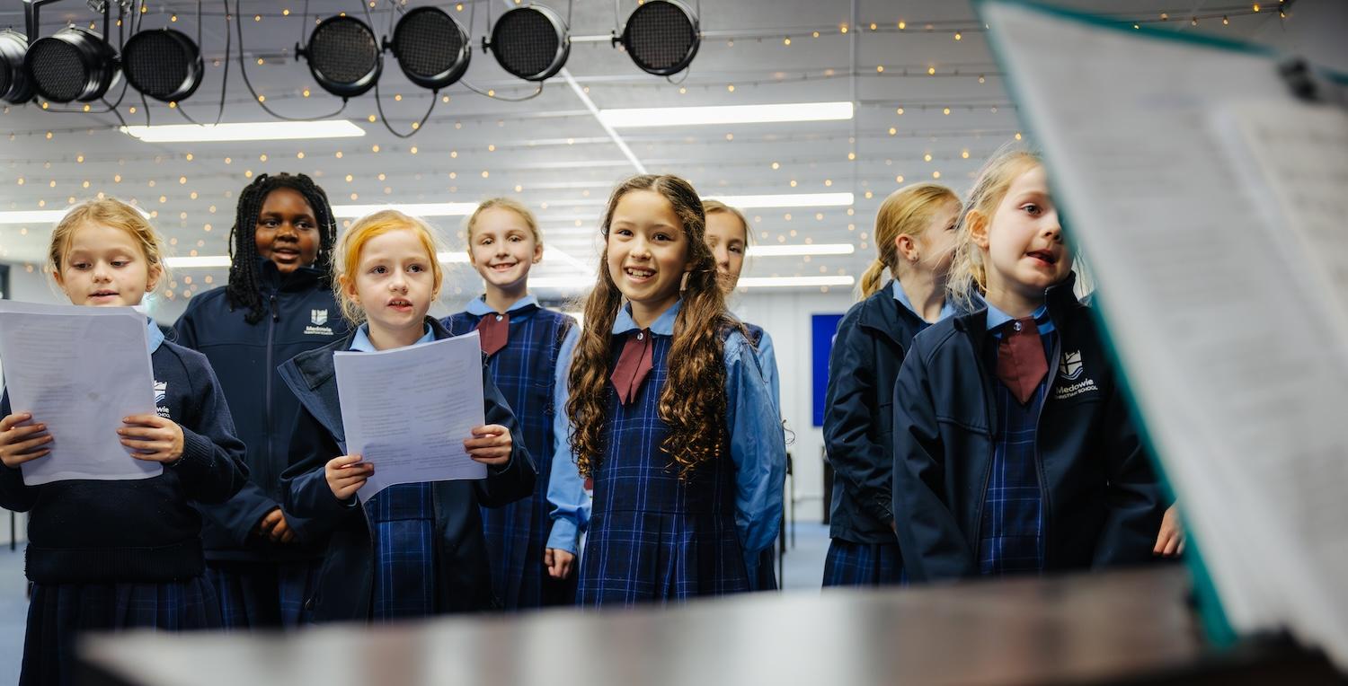 The primary choir at Medowie Christian School rehearsing in the music room with their teacher.