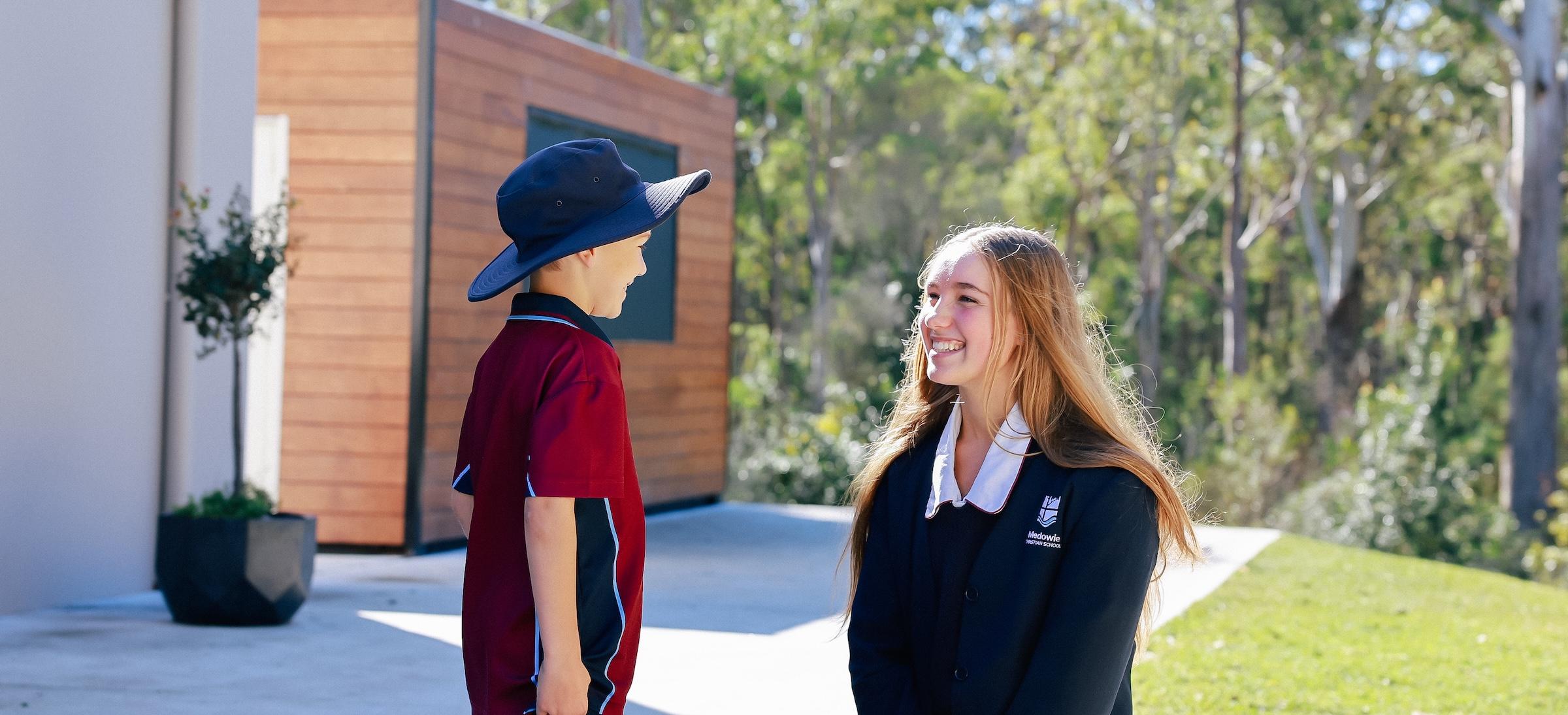Senior student smiling and engaging with a younger student, emphasising the love and support of the school community.