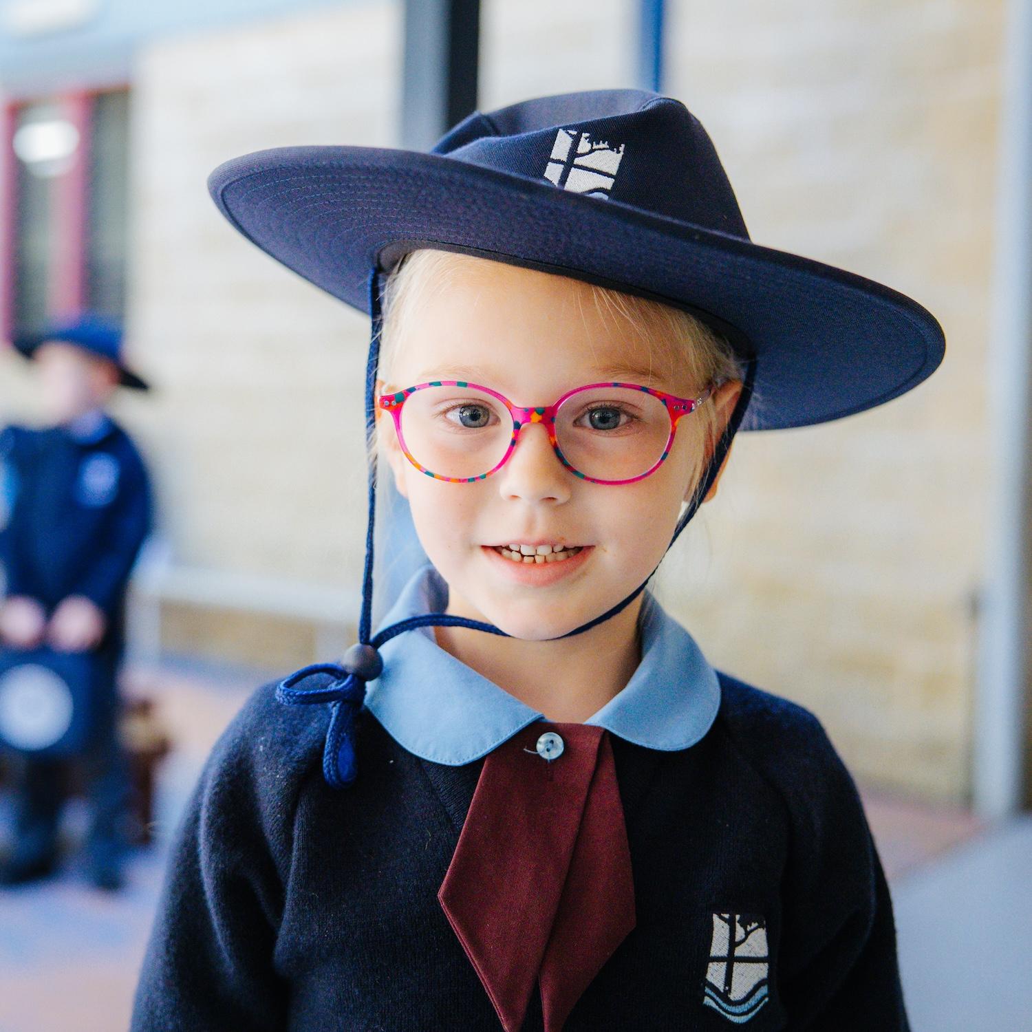 Primary school girl wearing a broad brim hat and pink glasses