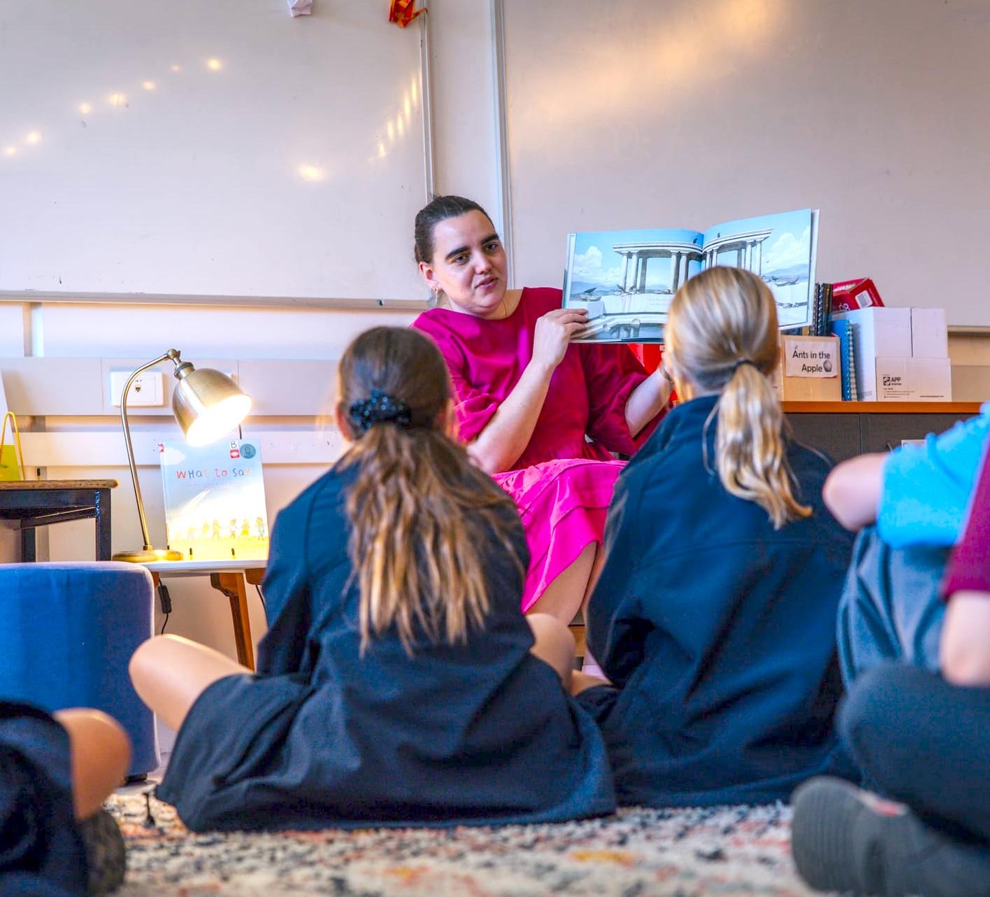 Teacher supporting two students with learning activities at Medowie Christian School.